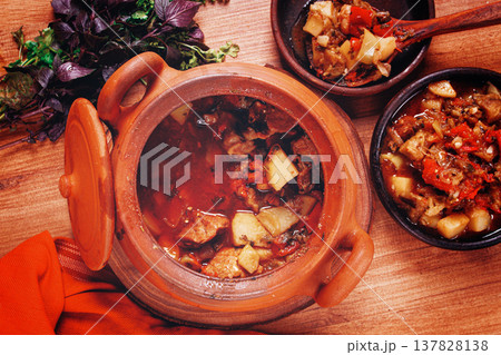 Chanakhi, a Georgian dish. in a clay pot, on a wooden table, stewed meat with vegetables, homemade, no people, 137828138