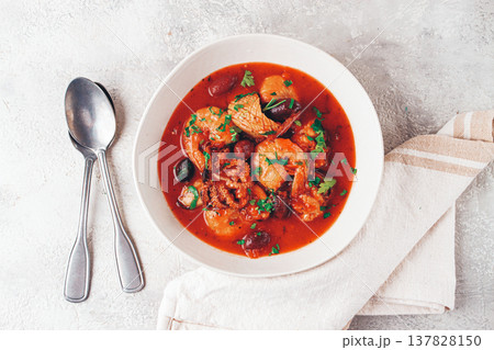seafood assortment in tomato sauce, olives, in a white plate, 137828150