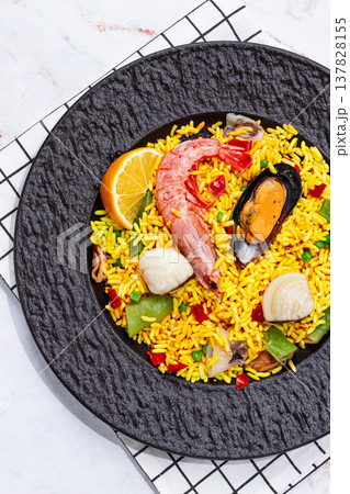 Seafood paella on a black plate, no people, 137828155