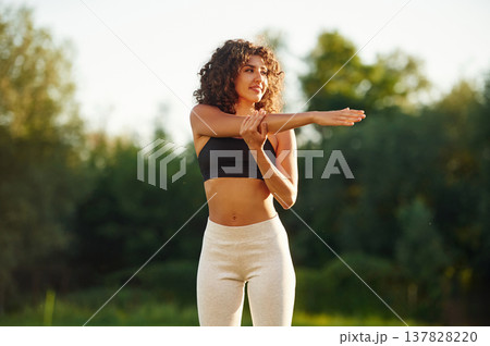 Hands exercises. Young fitness woman is on the field outdoors 137828220