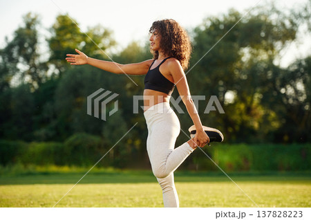 Hands exercises. Young fitness woman is on the field outdoors Hands exercises. Young fitness woman is on the field outdoors 137828223
