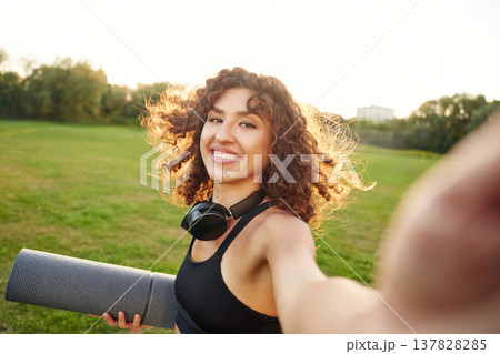 Photo for social media, doing selfie. Young fitness woman is on the field outdoors Photo for social media, doing selfie. Young fitness woman is on the field outdoors 137828285