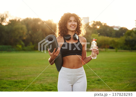 Friendly, positive facial expression, smiling. Young fitness woman is on the field outdoors 137828293