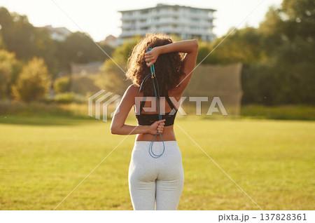 Rear view. Sportive woman doing fitness on the field 137828361