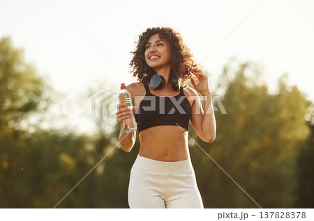 Good attitude, standing. Young fitness woman is on the field outdoors 137828378