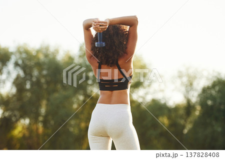 Rear view. Sportive woman doing fitness on the field 137828408