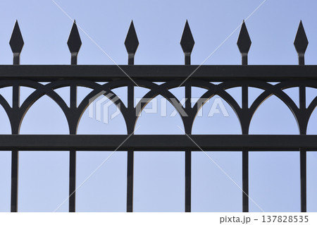 Black wrought iron fence with pointed spikes 137828535