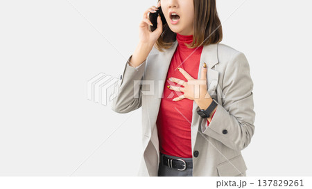 スマートフォンで話しながら驚く女性・ビジネスウーマン 137829261