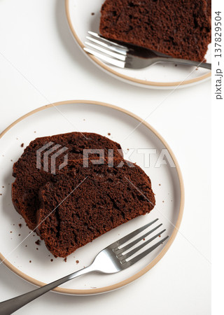 Slices of rich double chocolate pound cake on white plates. Top view Slices of rich double chocolate pound cake on white plates. Top view 137829504