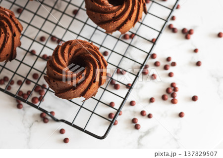 Mini chocolate bundt cakes on a cooling rack. Top view 137829507