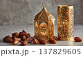 Luxurious Ramadan still life scene with golden lantern, ornate candle holder, and dates on marble surface, creating warm, festive, and elegant atmosphere for celebration 137829605