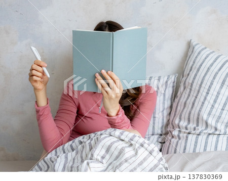 woman in bed writes in personal diary, writes down emotions, writes down wish list. mental health. 137830369