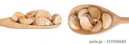 garlic cloves in wooden spoon isolated on white background close up. Top view. Flat lay. garlic cloves in wooden spoon isolated on white background close up. Top view. Flat lay. 137830689
