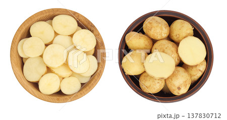 young potato slices in wooden and ceramic bowl isolated on white background. Harvest new. Top view. Flat lay. young potato slices in wooden and ceramic bowl isolated on white background. Harvest new. Top view. Flat lay. 137830712