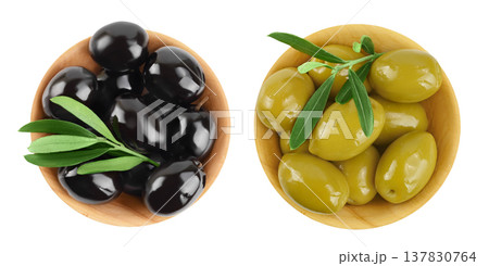 Black and green olives with leaves in wooden bowl isolated on a white background with full depth of field. Top view. Flat lay Black and green olives with leaves in wooden bowl isolated on a white background with full depth of field. Top view. Flat lay 137830764