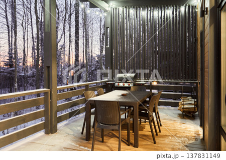 Tranquil rustic porch illuminated warmly for nighttime dining 137831149