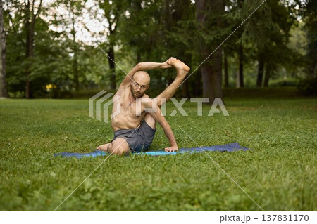 Serene individual performing seated flow in peaceful park environment Serene individual performing seated flow in peaceful park environment 137831170