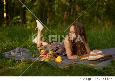 Calm young lady lying on blanket amidst peaceful nature scenery 137831187