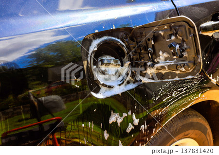 Car cleaning process showing gas cap area being washed at garage 137831420