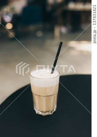 Glass of tasty latte on a table in a street cafe. Glass of tasty latte on a table in a street cafe. 137831821