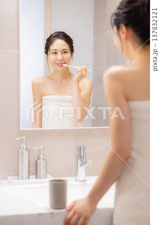 バスルームで歯磨きをする若い女性 バスルームで歯磨きをする若い女性 137832121