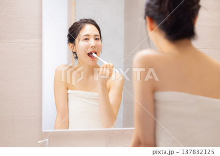 バスルームで歯磨きをする若い女性 137832125
