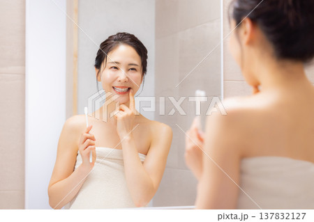 バスルームで歯磨きをする若い女性 137832127