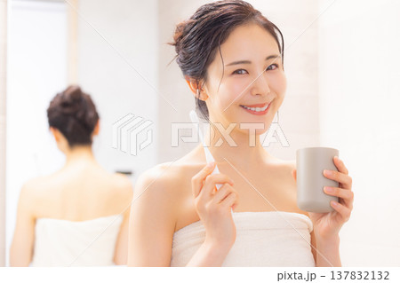 バスルームで歯磨きをする若い女性 バスルームで歯磨きをする若い女性 137832132