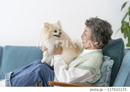 愛犬とくつろぐ笑顔のシニア女性　 137832235