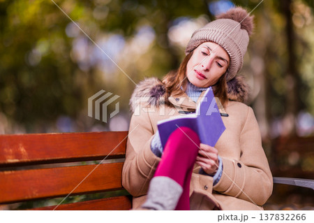 Woman journaling on park bench dealing with eating disorder Woman journaling on park bench dealing with eating disorder 137832266