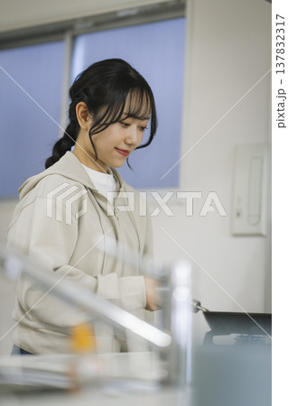 キッチンで料理をする若い女性　 137832317