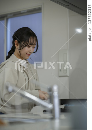 キッチンで料理をする若い女性　 137832318
