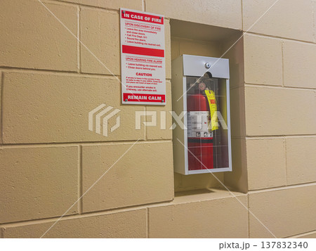 Fire extinguisher and safety sign in hallway Fire extinguisher and safety sign in hallway 137832340
