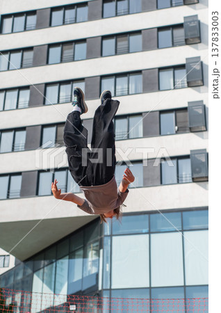 A girl jumps on an outdoor trampoline. 137833003