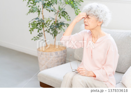 目頭を押さえるシニア女性 137833618