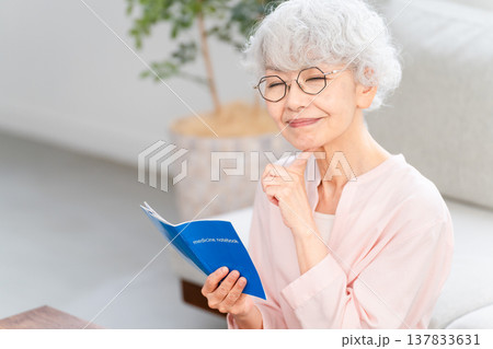 おくすり手帳を確認するシニア女性 137833631
