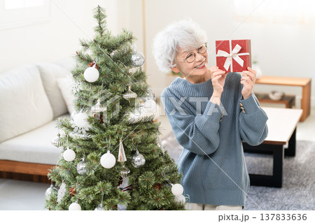 クリスマスプレゼントを持っているシニア女性 クリスマスプレゼントを持っているシニア女性 137833636