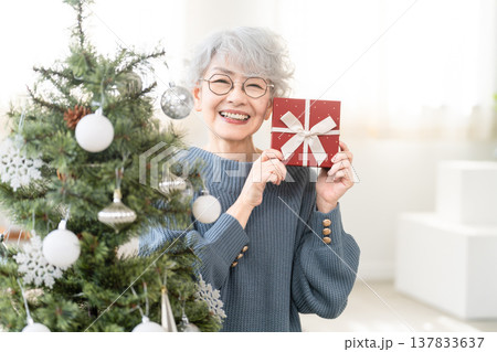 クリスマスプレゼントを持っているシニア女性 クリスマスプレゼントを持っているシニア女性 137833637