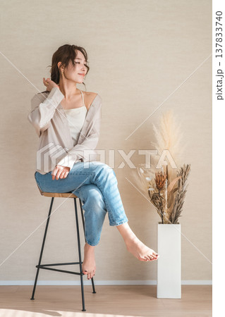 ハイチェア,椅子に座るデニム姿の女性モデル 137833740