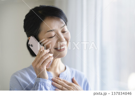 スマートフォンで通話する50代後半の女性 137834846