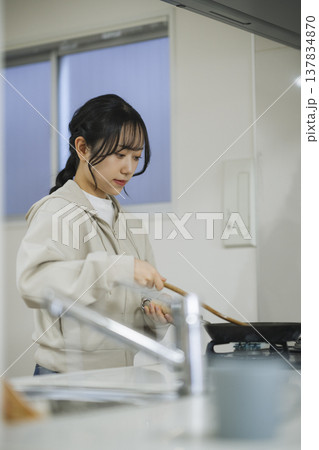 キッチンで料理をする若い女性　 137834870