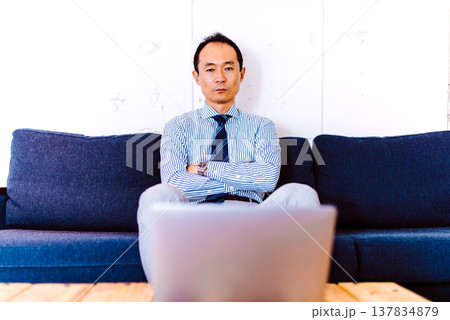 ソファでPCに向かう考え込む日本人男性 137834879