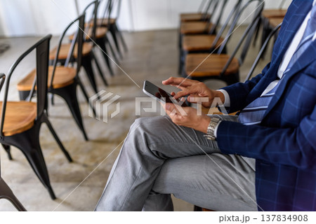 会議でスマートフォンを操作する男性 会議でスマートフォンを操作する男性 137834908