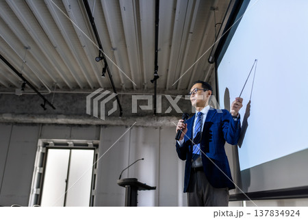 スーツ姿の講師がポインターで説明 137834924