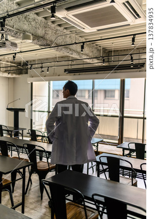 白衣の医師が広い講義室を見渡す 白衣の医師が広い講義室を見渡す 137834935