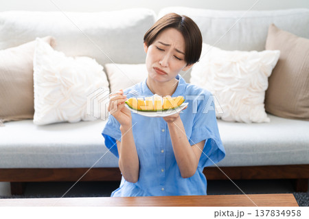 メロンを食べる若い女性　ライフスタイルイメージ 137834958