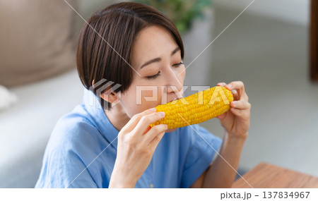 トウモロコシを食べる若い女性　ライフスタイルイメージ 137834967
