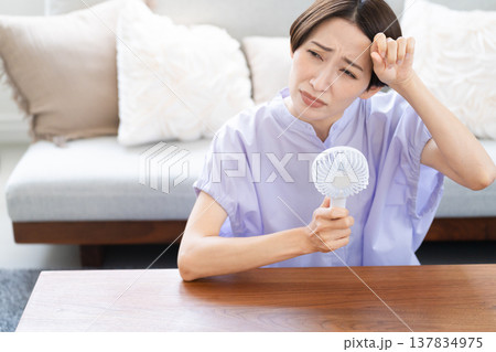 ハンドファンを使う若い女性　ライフスタイルイメージ 137834975