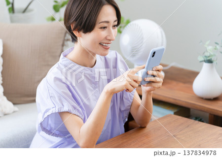 スマートフォンを操作する若い女性　ライフスタイルイメージ 137834978