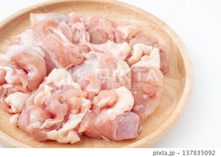 木製のお皿に載せた生の鶏もも肉のぶつ切り 木製のお皿に載せた生の鶏もも肉のぶつ切り 137835092